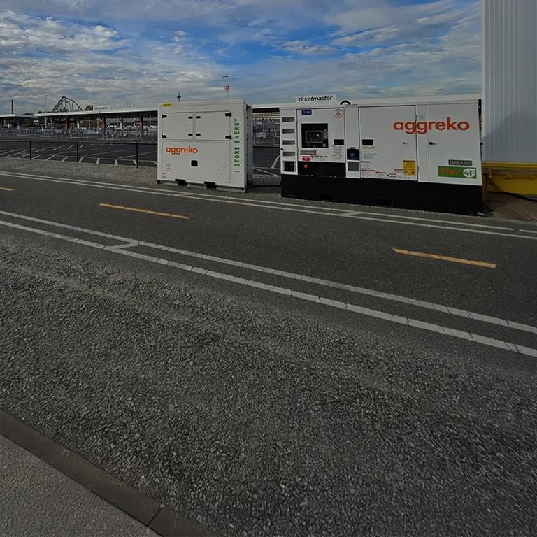 A white Aggreko Energy Battery sitting on an event's grounds.
