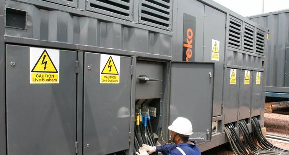 A technician working on an Aggreko transformer