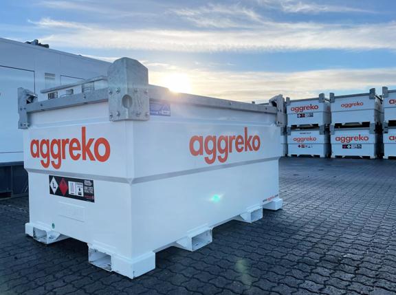 A white Aggreko fuel tank at a worksite with a row of more fuel tanks behind it