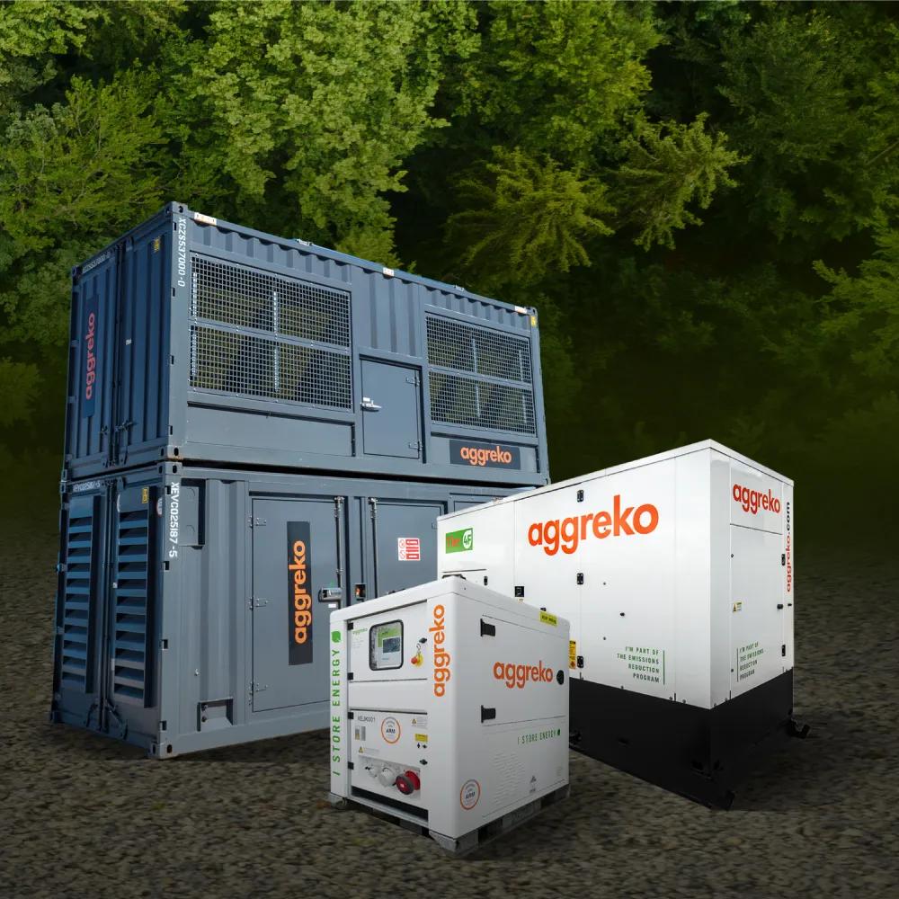 Three Aggreko power units placed in front of a green, tree-filled background.