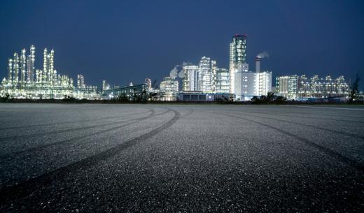 Asphalt parking lot outside the chemical plant at night