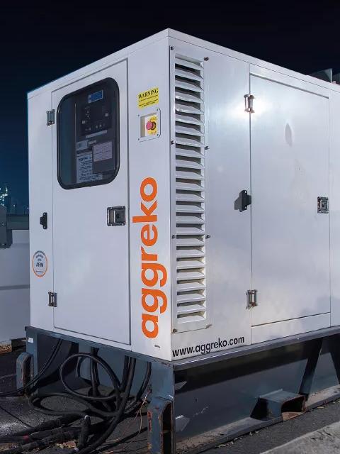 Aggreko backup and emergency generator with a city at night background