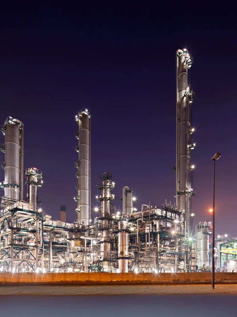 Night-view of a lit-up refinery at a distance.