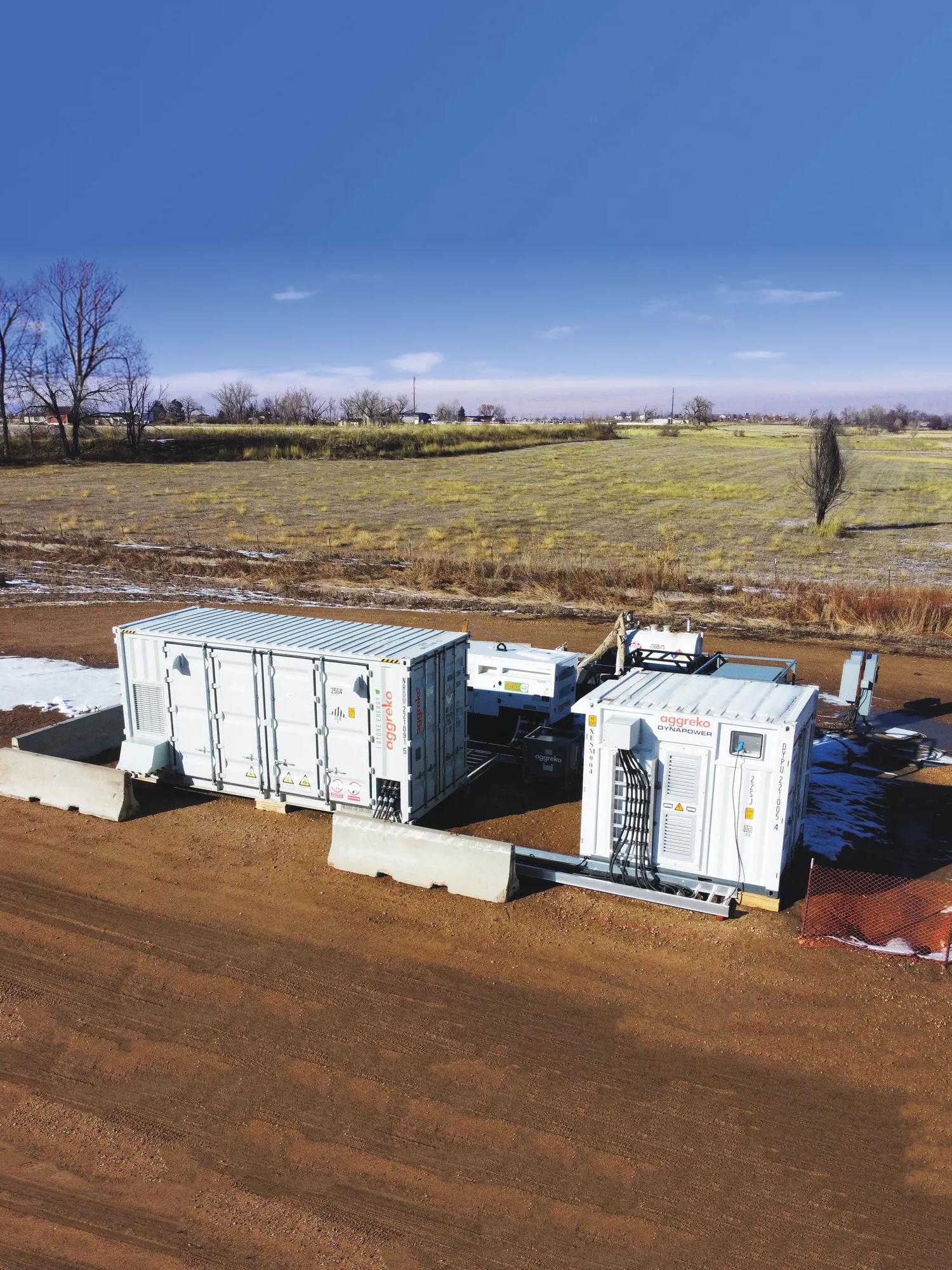 Two white Aggreko batteries at a worksite