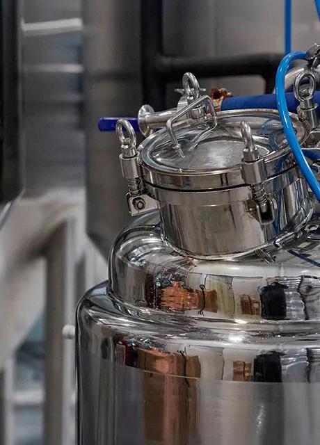 Stainless steel industrial processing equipment with pipes and gauges.