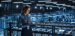 Data Center Female It Specialist Using Laptop. Server Farm Cloud Computing and Cyber Security Maintenance Administrator Working on Computer. Information Technology Professional.