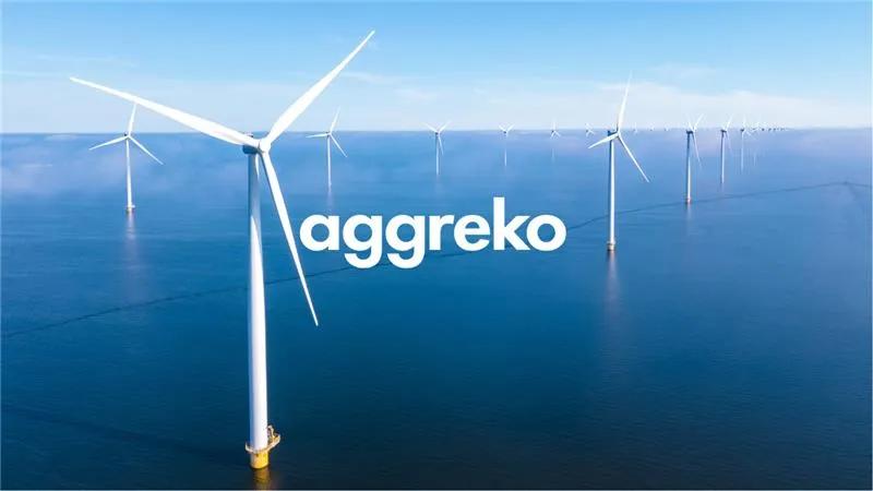 Aerial view of several wind turbines standing on a large body of water.  