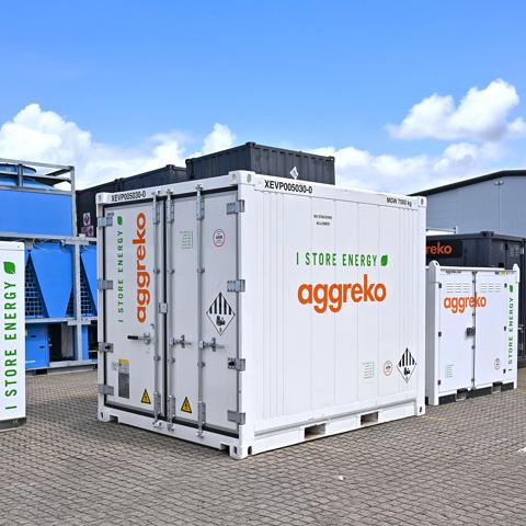 Multiple white, containerized industrial Aggreko units outdoors.