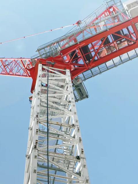 Close-up of Large red and white building crane against sky.