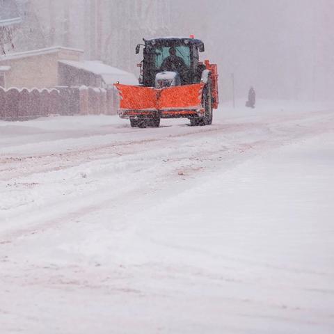 Snowplow clearing a road during heavy snowfall  