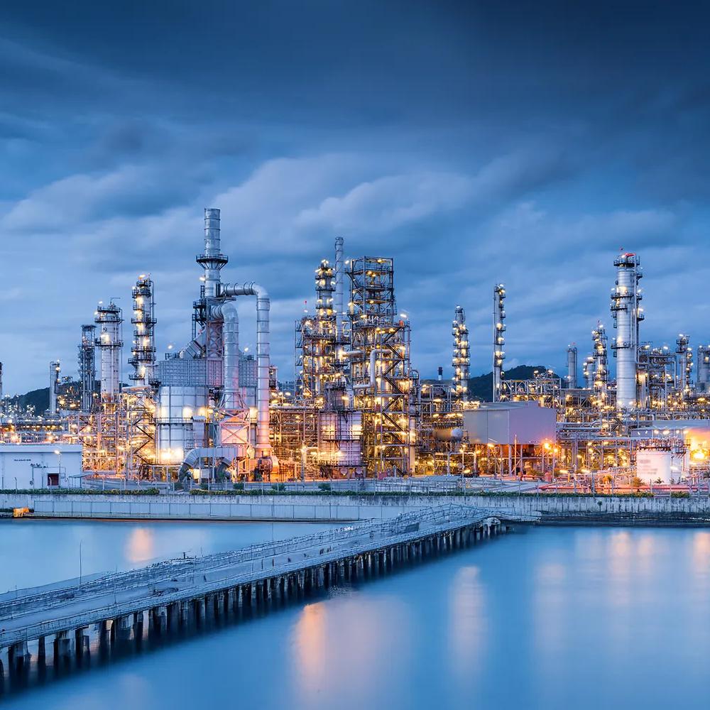 A wide view of an intricate petrochemical refinery at twilight.