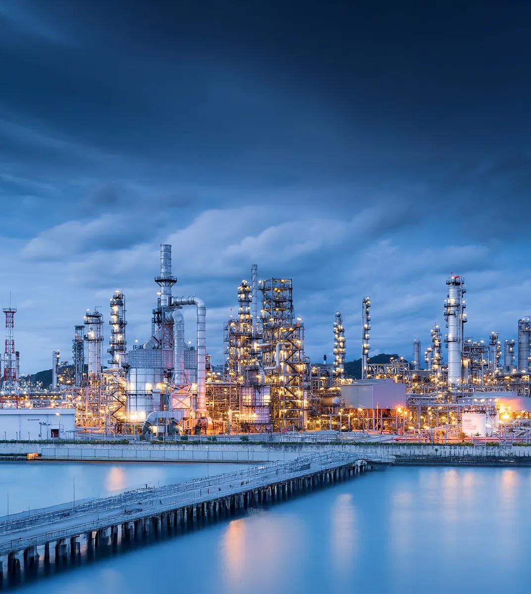 A wide view of an intricate petrochemical refinery at twilight.