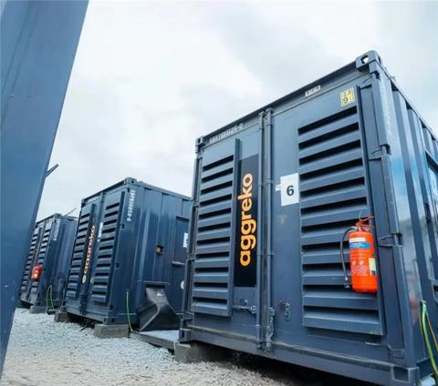 A row of three black Aggreko gas generators at a worksite