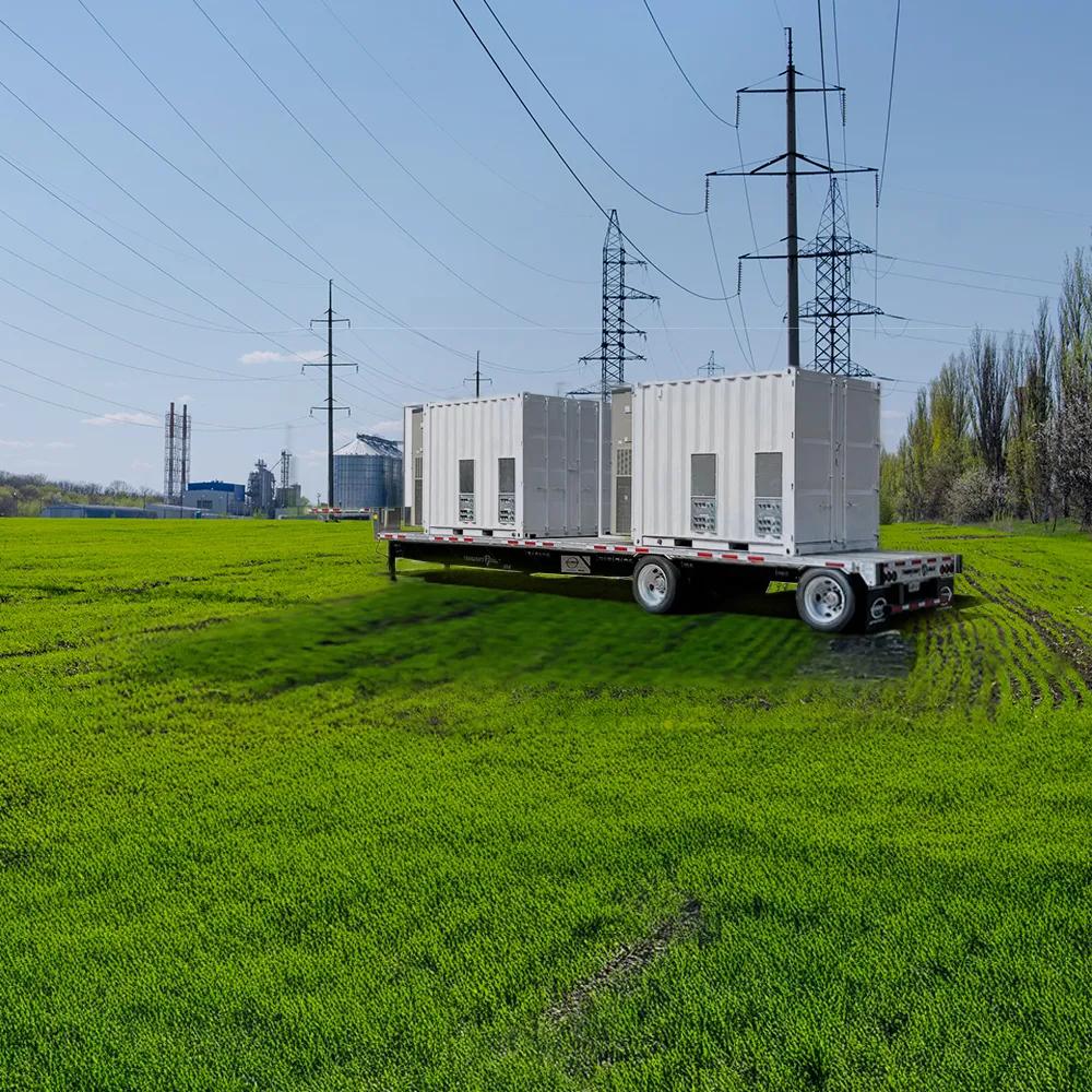 Transformer in a field with a power plant in the background.