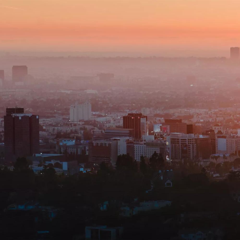 View of a city's skyline at noon with pollution on the horizon