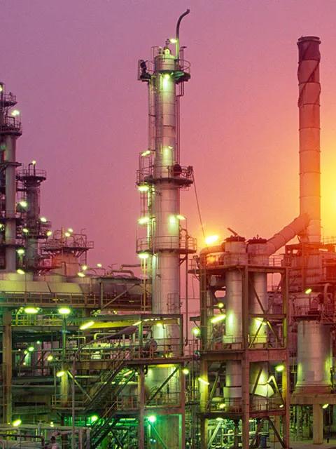 Industrial refinery complex illuminated at sunset.