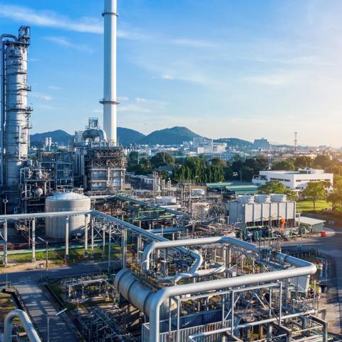 Aerial view of chemical oil refinery plant, power plant on blue sky background.