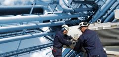 Two oil and gas workers with large fuel pipelines.