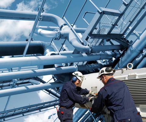 Two oil and gas workers with large fuel pipelines.