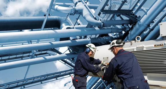 Two oil and gas workers with large fuel pipelines.