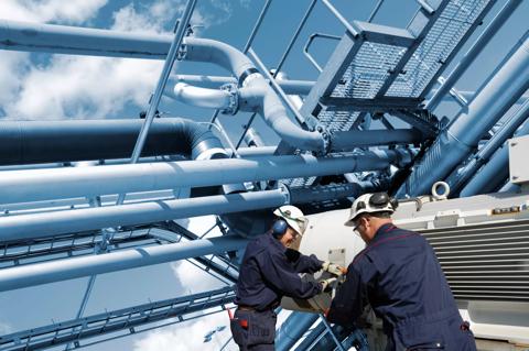 Two oil and gas workers with large fuel pipelines.