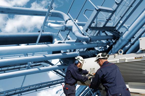 Two oil and gas workers with large fuel pipelines.