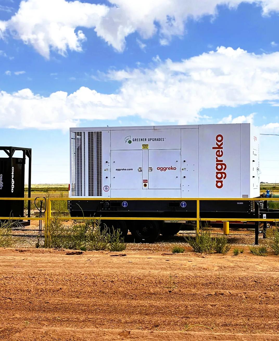 An outdoor panoramic view of a containerized hybrid energy solution installed on in a desert-like landscape