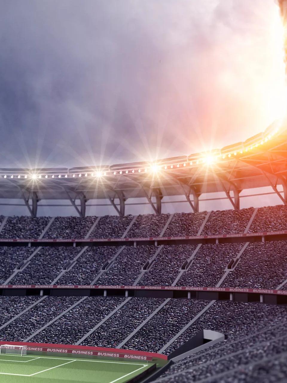 Inside shot of a stadium's bleachers and lights at night.