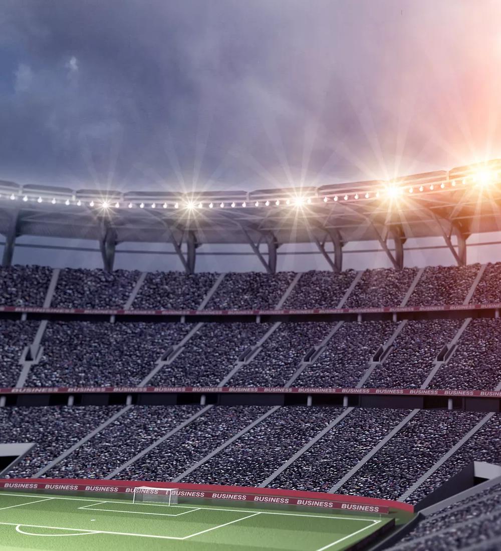 Inside shot of a stadium's bleachers and lights at night.