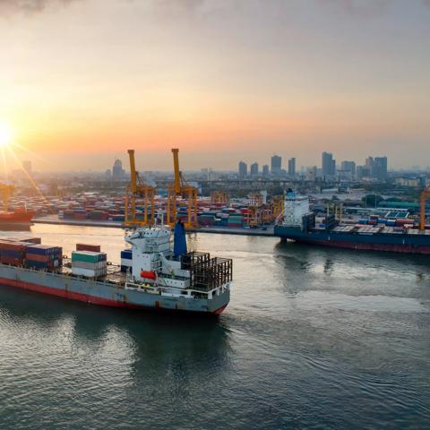 Containers yard in port congestion with ship vessels are loading and discharging operations of the transportation in international port.Shot from drone.