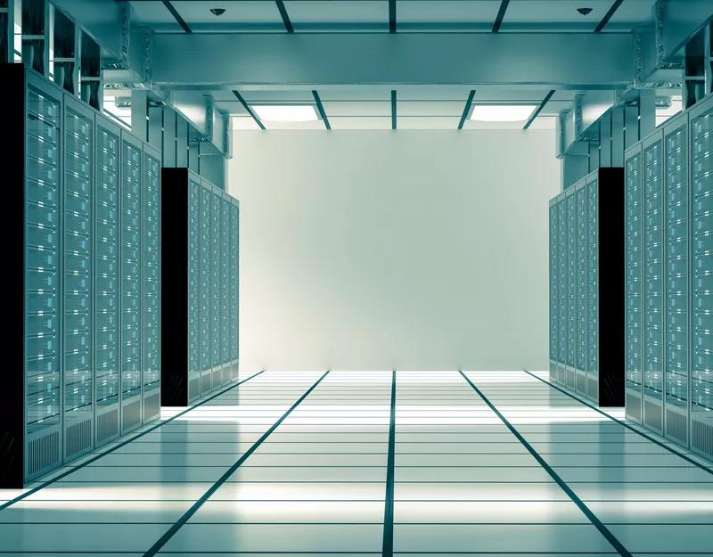 A side view of several rows of dark gray or black server hardware racks, showing the cable management and hardware depth within the server frames.