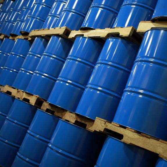 Blue oil drums stacked in a warehouse in Indiana, U.S. Photographer: Luke Sharrett/Bloomberg