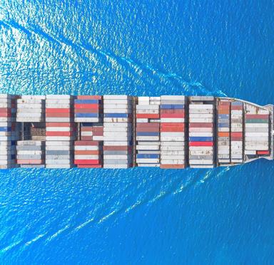 Aerial top view container ship full load container wih beautiful wave pattern for logistics import export, shipping or transportation concept.