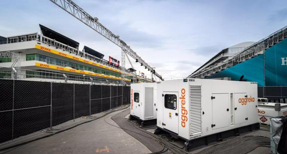 Two white Aggreko generators outside a stadium