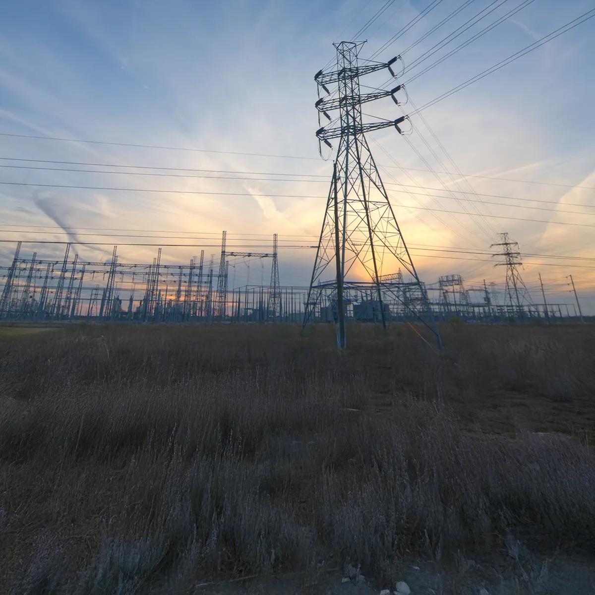 transmission tower against a clowdy blue sky