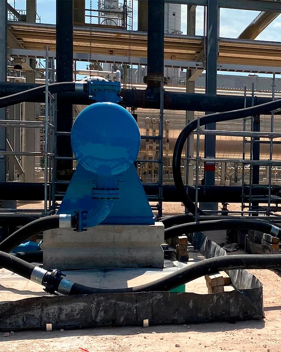 View of a large, blue industrial unit with industrial machinery is visible in the background.