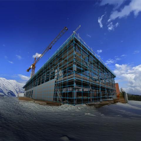 A data center under construction in the middle of a snowy landscape with pines
