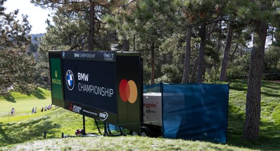 View of a portable generator behind a digital scoreboard at a golf tournament.