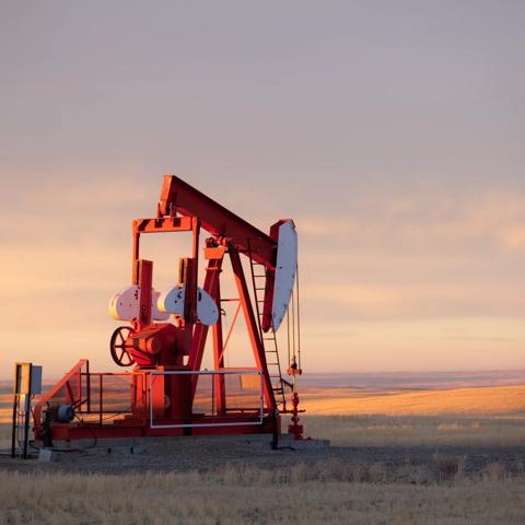 A pumpjack on the prairie. Alberta, Canada. This oil rig is located near Turner Valley, Alberta in an area where the oil industry is a major economic driver. Additional themes include crude oil, oil field, oilsands, prairie, rural, gas, fossil fuel, environment, energy, economy, rolling hills, scenic, southern alberta, red, agriculture, industry, equipment, and autumn.