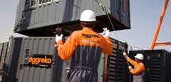 Technicians moving gas generators with crane