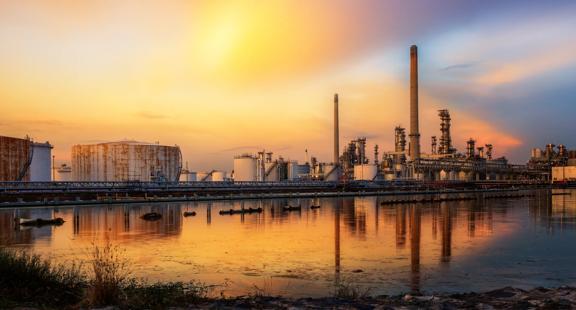Panoramic view of a petrochemical plant at sunsent with the reflexion over a lake