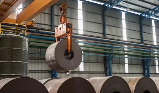 Image of crane loading of metal steel rolls.