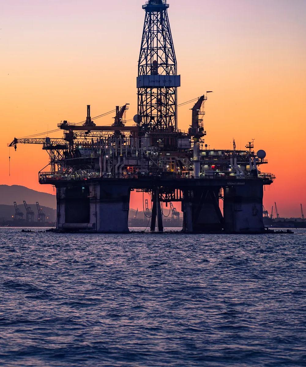 Onshore oil and gas treatment plant against a sunset sky