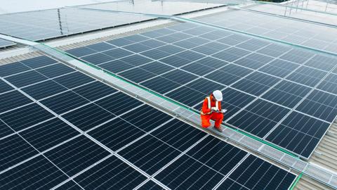 Electrical engineers are using laptops to monitor the operation of the solar rooftop. Renewable energy concepts.