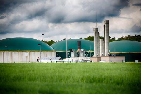Wide angle shot of a modern biogas plant under a great cloudscape. Toned picture and vignette added.