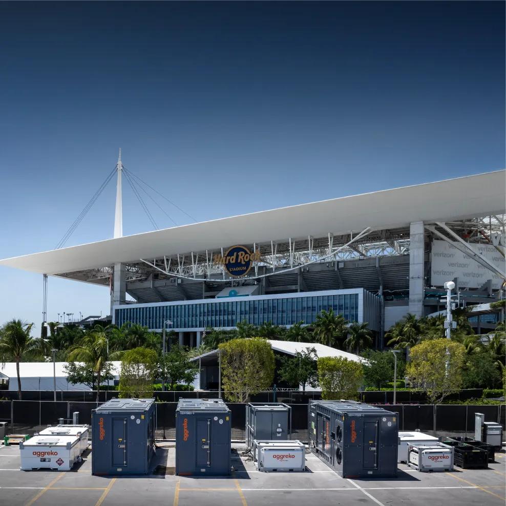 Various  Aggreko power units in a parking lot with Hard Rock Cafe in the back.